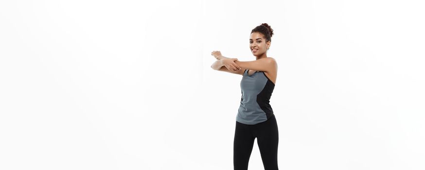 Sport, training, lifestyle and Fitness concept - Full-length portrait of beautiful happy African American woman stretching hands. Isolated on white studio background