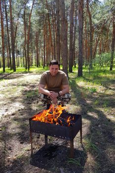 Man cooking Raw kebab, grilling on metal skewer. Meat roasting at barbecue. BBQ fresh beef chop slices. Traditional eastern dish. Grill on charcoal and flame, picnic, street food