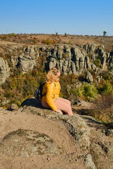 Hiker young woman with backpack on trekking trail looking at sea bay landscape