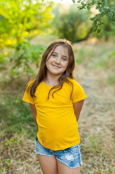 Outdoor Portrait of a Smiling Little Girl in a yellow t-shirt