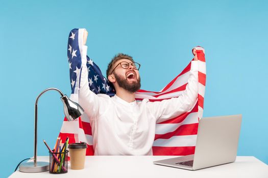 Delighted enthusiastic businessman raising American flag and screaming for joy in office workplace, celebrating labor day or US Independence day 4th of july, government support. studio shot isolated