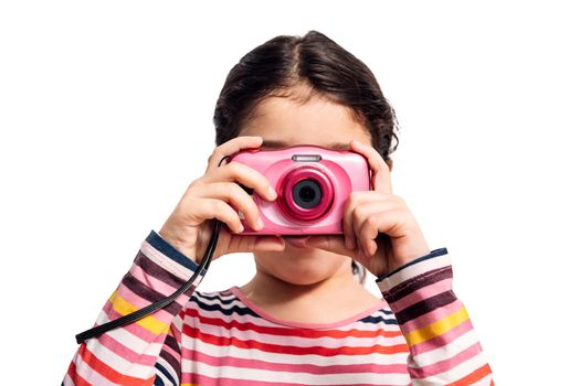 horizontal photo of a little girl isolated on a white background taking pictures with her pink camera, concept of children and their hobbies