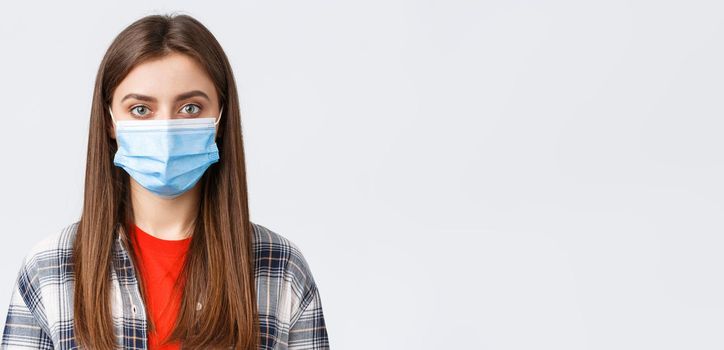 Coronavirus outbreak, leisure on quarantine, social distancing and emotions concept. Close-up of young female student, girl in medical mask looking at camera, normal expression.