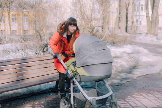 Mom on a walk with a stroller lifestyle. An article about choosing a stroller. An article about walking with children. The use of fresh air for kids. Modern moms. City walks with a stroller .