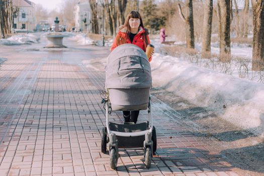 Mom on a walk with a stroller lifestyle. An article about choosing a stroller. An article about walking with children. The use of fresh air for kids. Modern moms. City walks with a stroller .