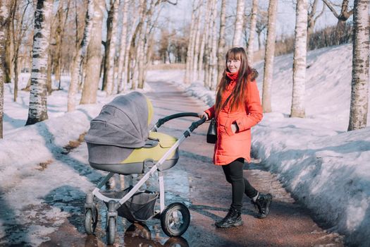 Mom on a walk with a stroller lifestyle. An article about choosing a stroller. An article about walking with children. The use of fresh air for kids. Modern moms. City walks with a stroller .