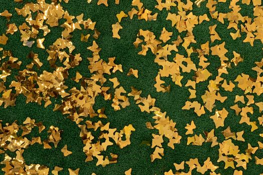 decorative shiny golden stars confetti on green background