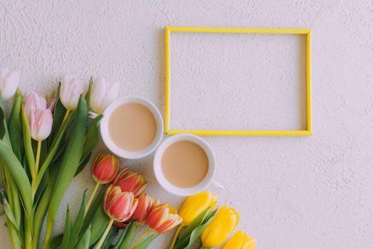 Tulips and a frame on a gray background . Tulips of kopi space. Gray background. Mockup . Space for text. A greeting card. Tulips on a gray background. Spring flowers. March eighth. Mother's Day. Birthday