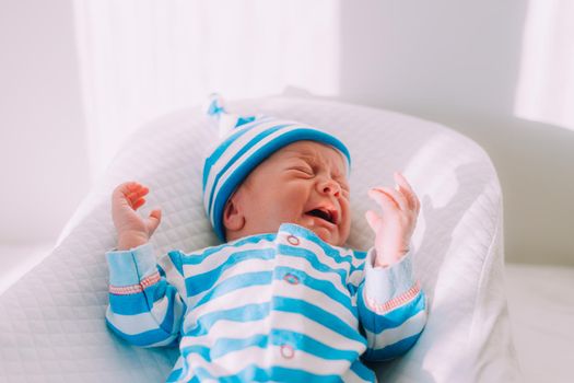 The baby is lying in a cocoon of copy space . The baby is 0-3 months old. A contented infant. An article about choosing a cocoon for newborns. An article about the benefits of cocoon. An article about colic .