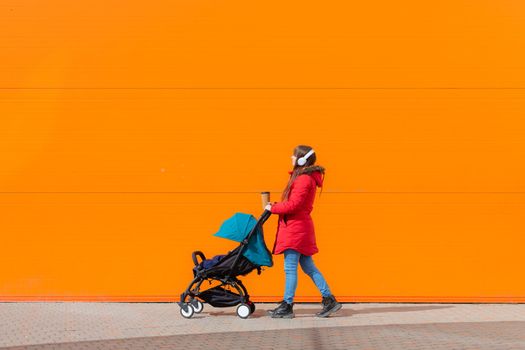 Mom on a walk with a stroller lifestyle. An article about choosing a stroller. An article about walking with children. The use of fresh air for kids. Modern moms. City walks with a stroller .