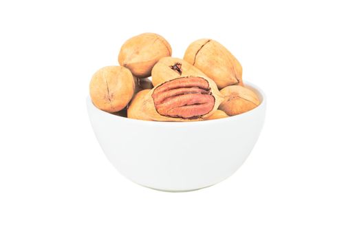 Shelled pecans in a ceramic light bowl on a white background
