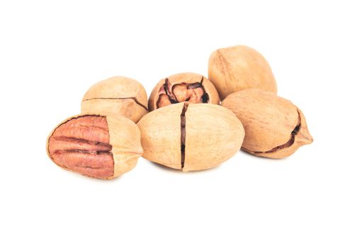 Heap of pecan nuts in broken shell on white background