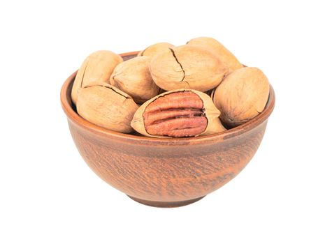 Pecan nuts in shell and bowl on white background