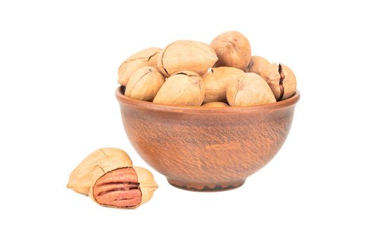 Pecan nuts in shell and bowl on white background