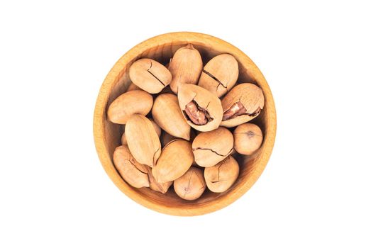 PeShelled pecans in wooden bowl us white background, top view