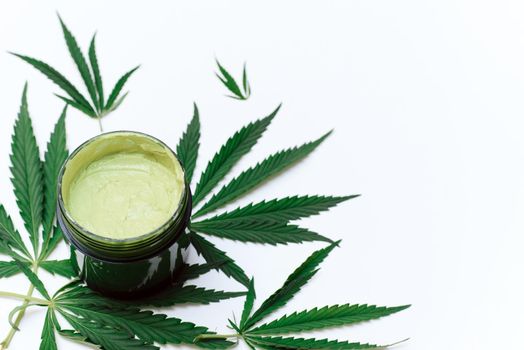 Green clay mask with hemp extract on a white background with copy space. use of cannabis in the creation of cosmetics