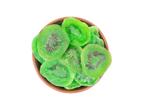 Dry kiwi slices in a ceramic bowl isolated on white background, top view