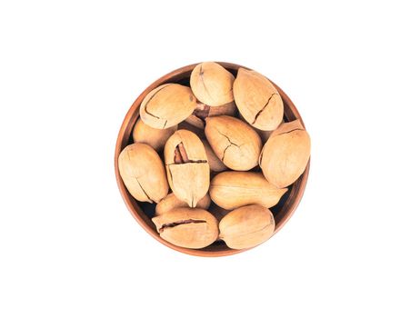 Pecan nuts in ceramic bowl isolated on white background, top view