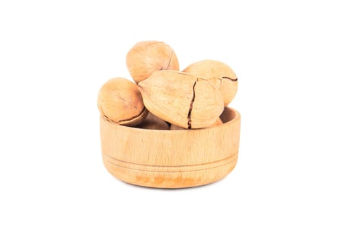 Pecan nuts in shell and small wooden bowl on white background