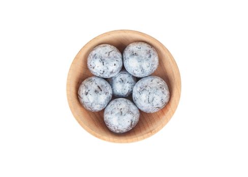 Hazelnuts in chocolate in a wooden bowl isolated on white background top view