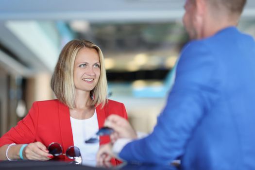 Smiling businesswoman communicates with a man in cafe. Acquaintance and business meeting concept