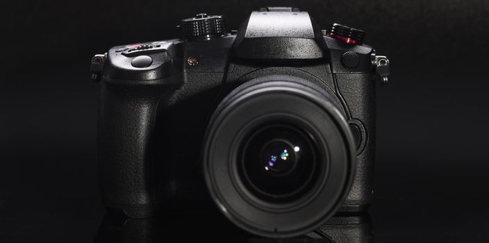 Black digital photo and video camera closeup background