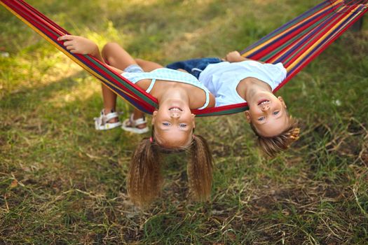 Fun in the garden. lovely kids playing in colorful hammock