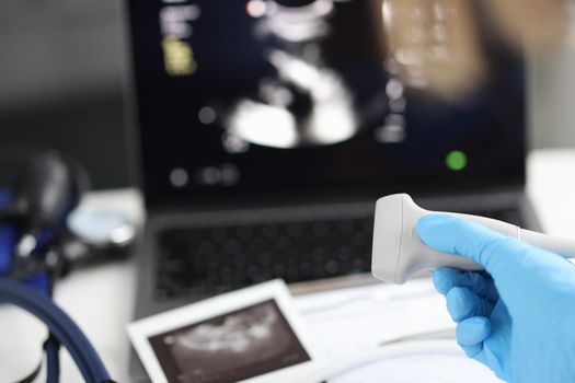 Doctor holds ultrasonic probe in hand preparing device for examination. Ultrasound of internal organs concept