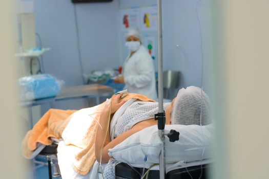 Woman surrounded by doctors. Preparation for surgery.