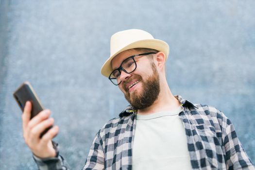 Smiling male tourist use smartphone during summer city break - technologies and social media app