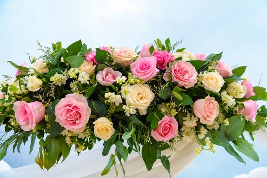 Scenery of flowers of white roses on a wedding arch.