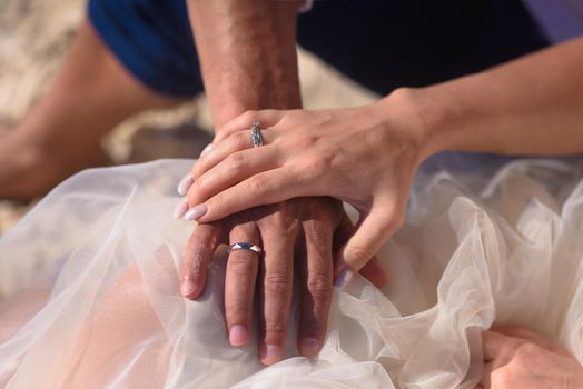 Man and woman newlyweds hold hands.