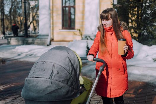 Mom on a walk with a stroller lifestyle. An article about choosing a stroller. An article about walking with children. The use of fresh air for kids. Modern moms. City walks with a stroller .