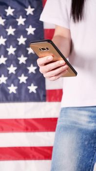 Hand holding and typing on mobile phone United states of America flag on background. Mockup phone. Social, communication, Labor day, 4th of July, Memorial day, 9.11