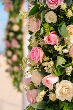 Scenery of flowers of white roses on a wedding arch.