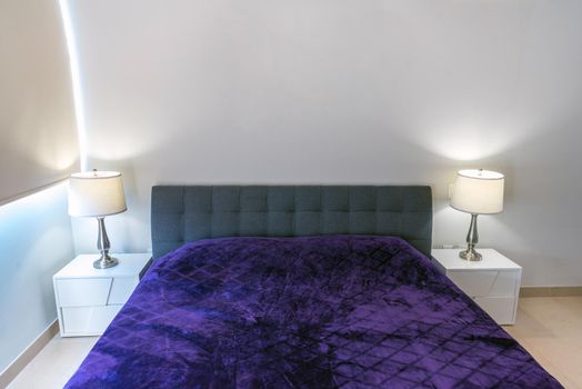 Double-bed with a violet coverlet in the interior