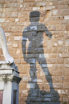 Shadow of statue of David by Michelangelo on Palazzo Vecchio of Florence. Piazza della Signoria, Tuscany, Italy