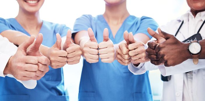 Shot of a group of unrecognizable doctors showing a thumbs up at a clinic.
