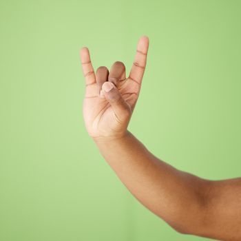 Cropped shot of a man showing a hand sign against a green background.