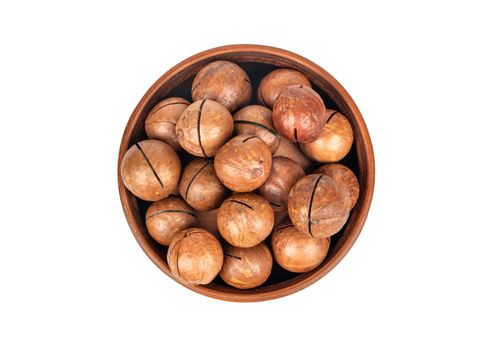 Macadamia nut in a ceramic bowl on a white background, top view