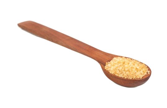 Wooden spoon with brown sugar on a white background