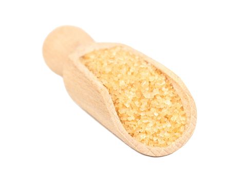 Brown sugar in a wooden scoop on a white background