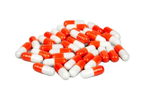 Pile of red and white capsules on a light background