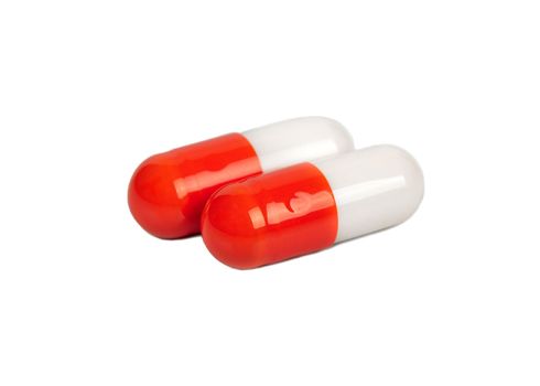 Two red and white capsules isolated on a white background