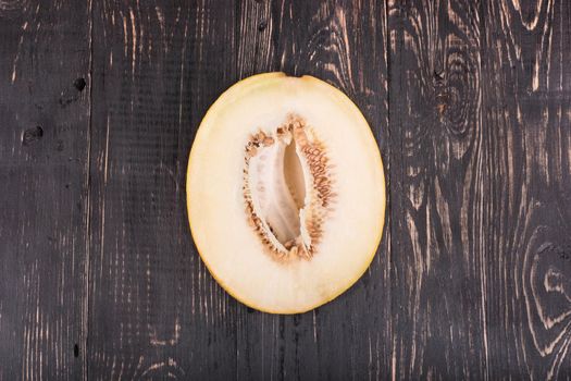 Ripe melon cut in half on a wooden background