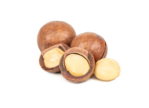 Split macadamia nuts with whole ones on a white background