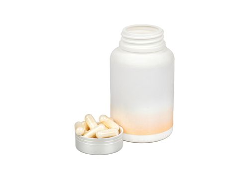 Capsules in a lid with a plastic jar isolated on a white background