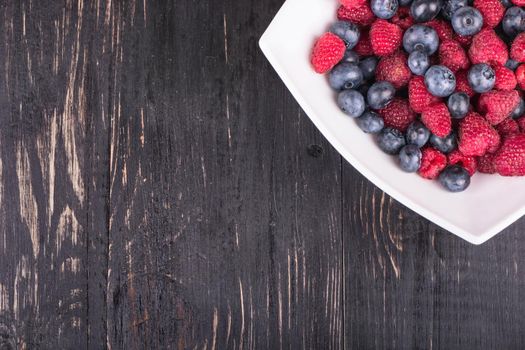 Part plates blueberry and raspberry filling on a dark wooden background top view