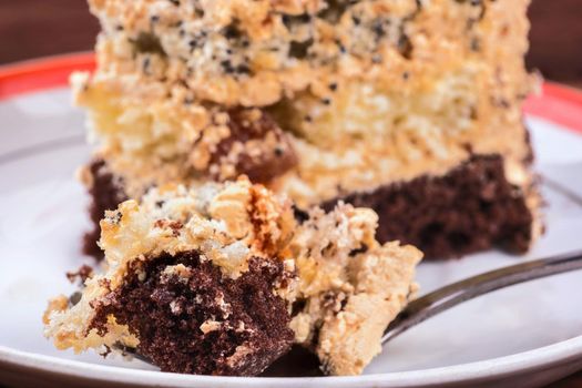 Piece of cake with chocolate cream and spoon close-up