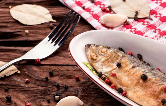 Small fried fish Baltic herring in a bowl on a table with spices